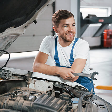 Automotive technician working at an open engine bay