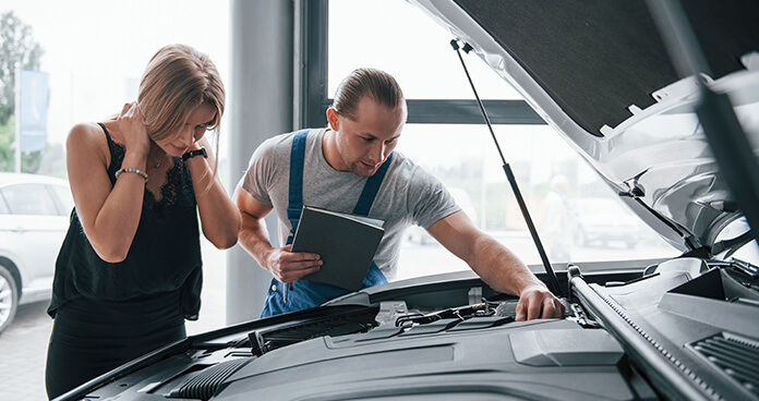 Technician explaining an engine-bay inspection to a customer