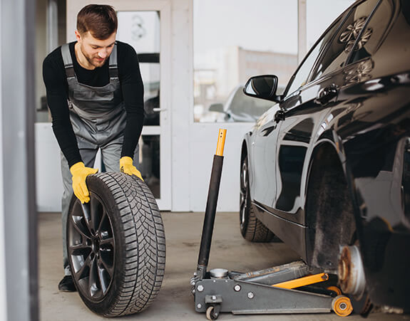 Technician removing a vehicle wheel in a workshop