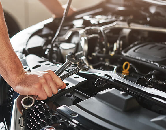 Mechanic working with spanners in an engine bay