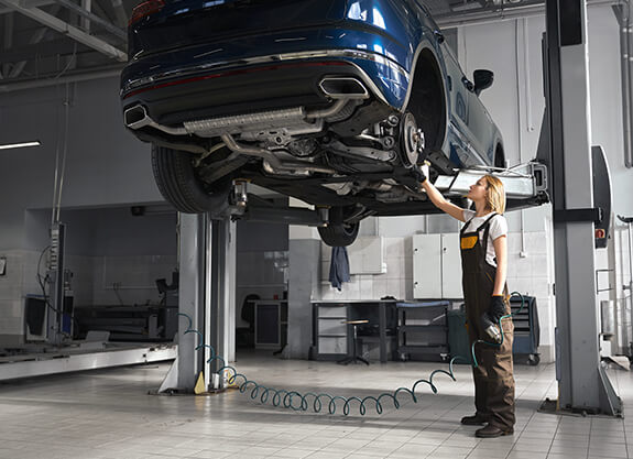 Technician inspecting a vehicle raised on a lift