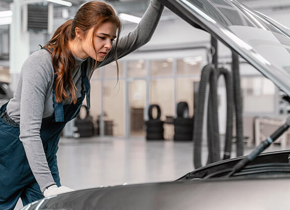 Technician inspecting an open engine bay