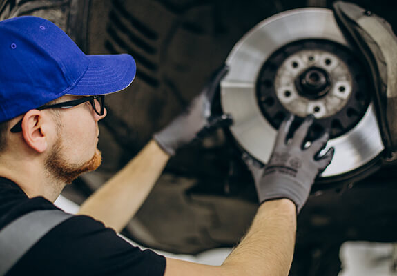 Technician inspecting a vehicle brake disc