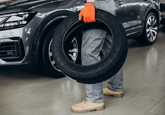 Technician carrying a replacement tyre