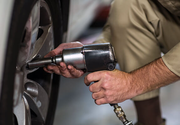 Technician tightening a vehicle wheel